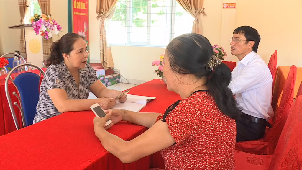 Bà Lê Thị Trường cùng lãnh đạo thôn Đông Sơn (xã Đông Xá) bàn kế hoạch tuyên truyền Luật Giao thông.