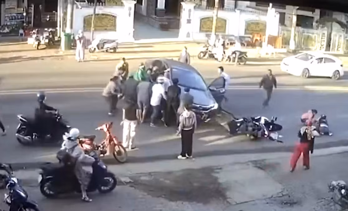 Người dân hợp sức nâng ô tô để cứu nạn nhân. (Ảnh cắt từ clip)