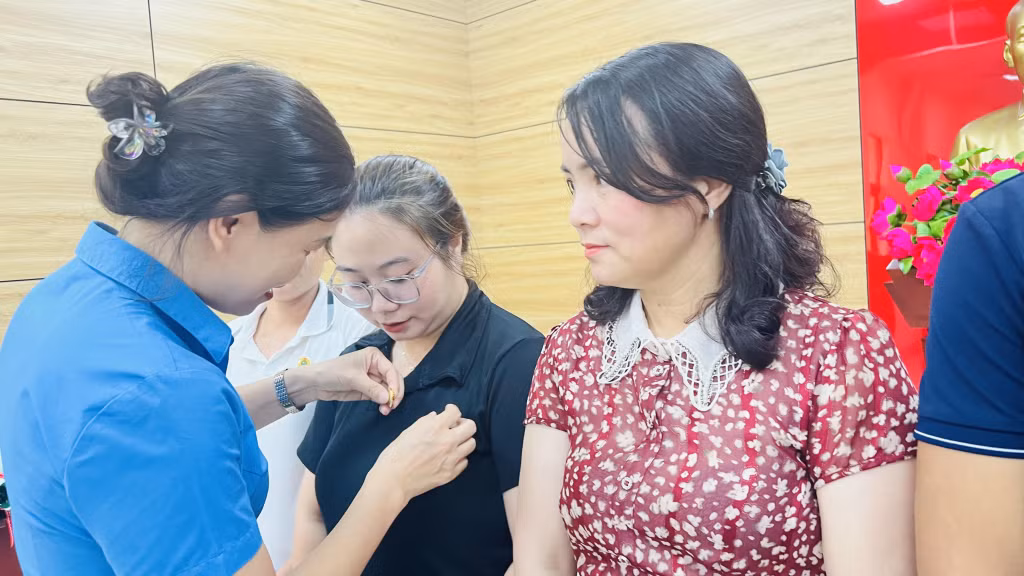 Lãnh đạo LĐLĐ Hạ Long gắn huy hiệu công đoàn cho đoàn viên mới.