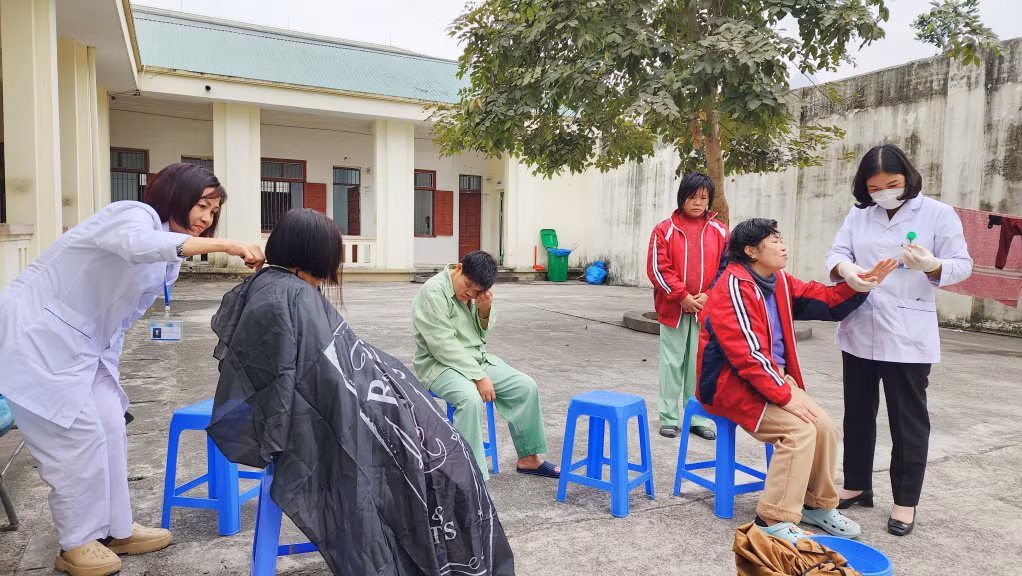 Điều dưỡng Thúy (ngoài cùng bên trái) đang cùng đồng nghiệp cắt tóc, cắt móng tay cho bệnh nhân.