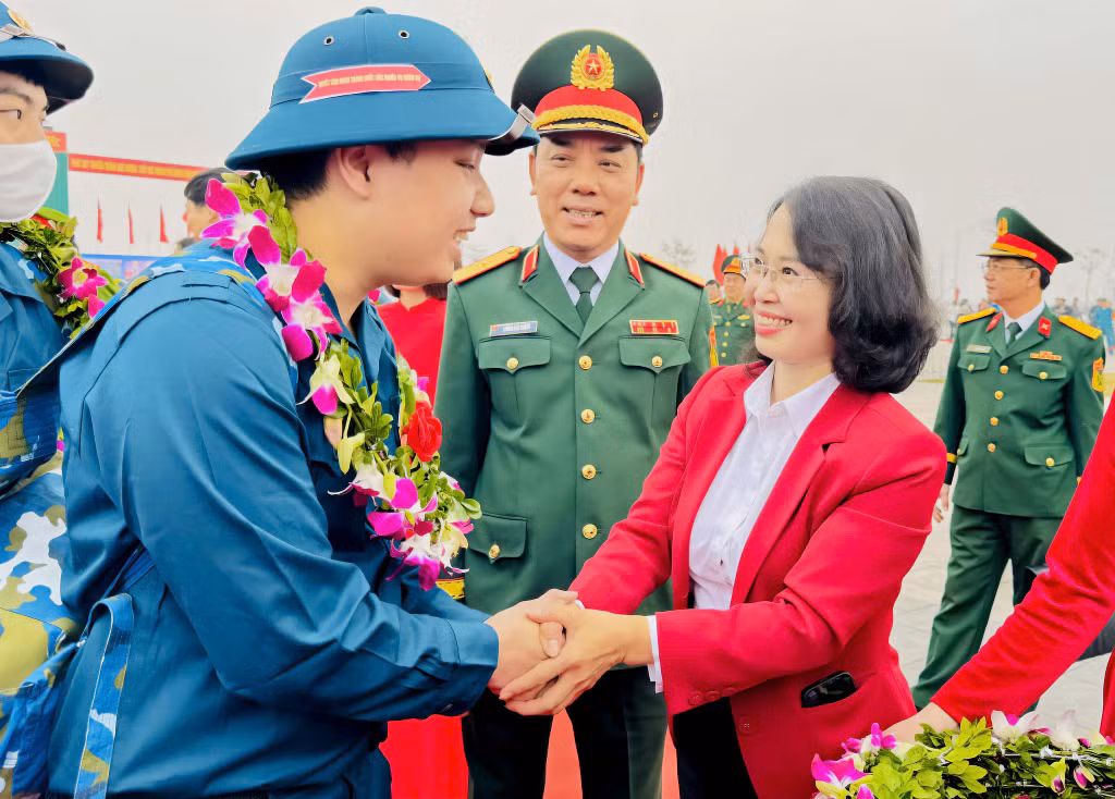 Đồng chí Trịnh Thị Minh Thanh, Phó Bí thư Thường trực Tỉnh ủy, Chủ tịch HĐND tỉnh, tặng hoa, chúc mừng tân binh lên đường nhập ngũ.