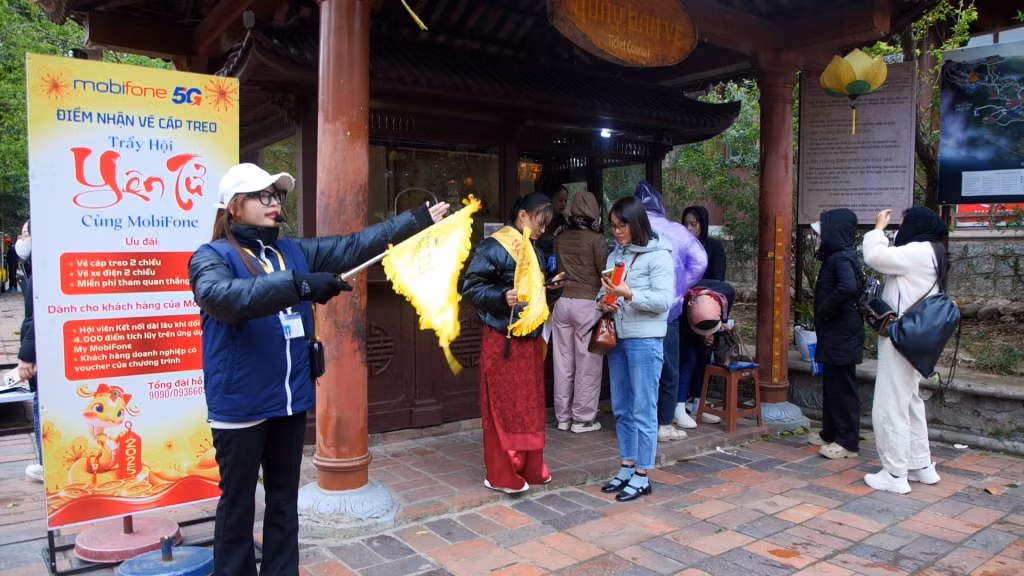 Nhân viên Công ty CP Phát triển Tùng Lâm hướng dẫn du khách tham quan tại Yên Tử.