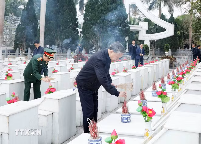 Tổng Bí thư Tô Lâm thắp hương trên phần mộ các liệt sỹ tại Nghĩa trang Liệt sỹ Quốc gia Vị Xuyên. (Ảnh: Thống Nhất/TTXVN)