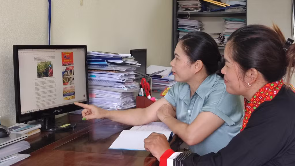 Chị Phùn Nhì Múi (phải) và chị Lô Thị Dung, Chủ tịch Hội LHPN xã Đồng Tâm, học tập mô hình phát triển kinh tế trên báo mạng điện tử.