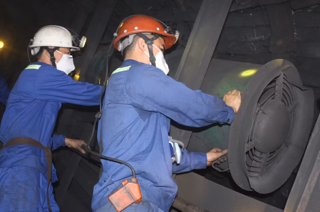 Thợ lò Trương Công Đông (đứng đầu từ phải sang) kiểm tra quạt gió cục bộ để điều chỉnh hạ áp nhánh lò chợ.
