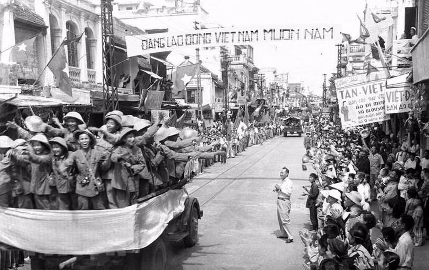 Đoàn xe chở các chiến sĩ Đại đoàn 308 tiến qua phố Hàng Đào, sáng 10/10/1954 trong niềm hân hoan chào đón của hàng vạn người dân. (Ảnh: Tư liệu TTXVN)