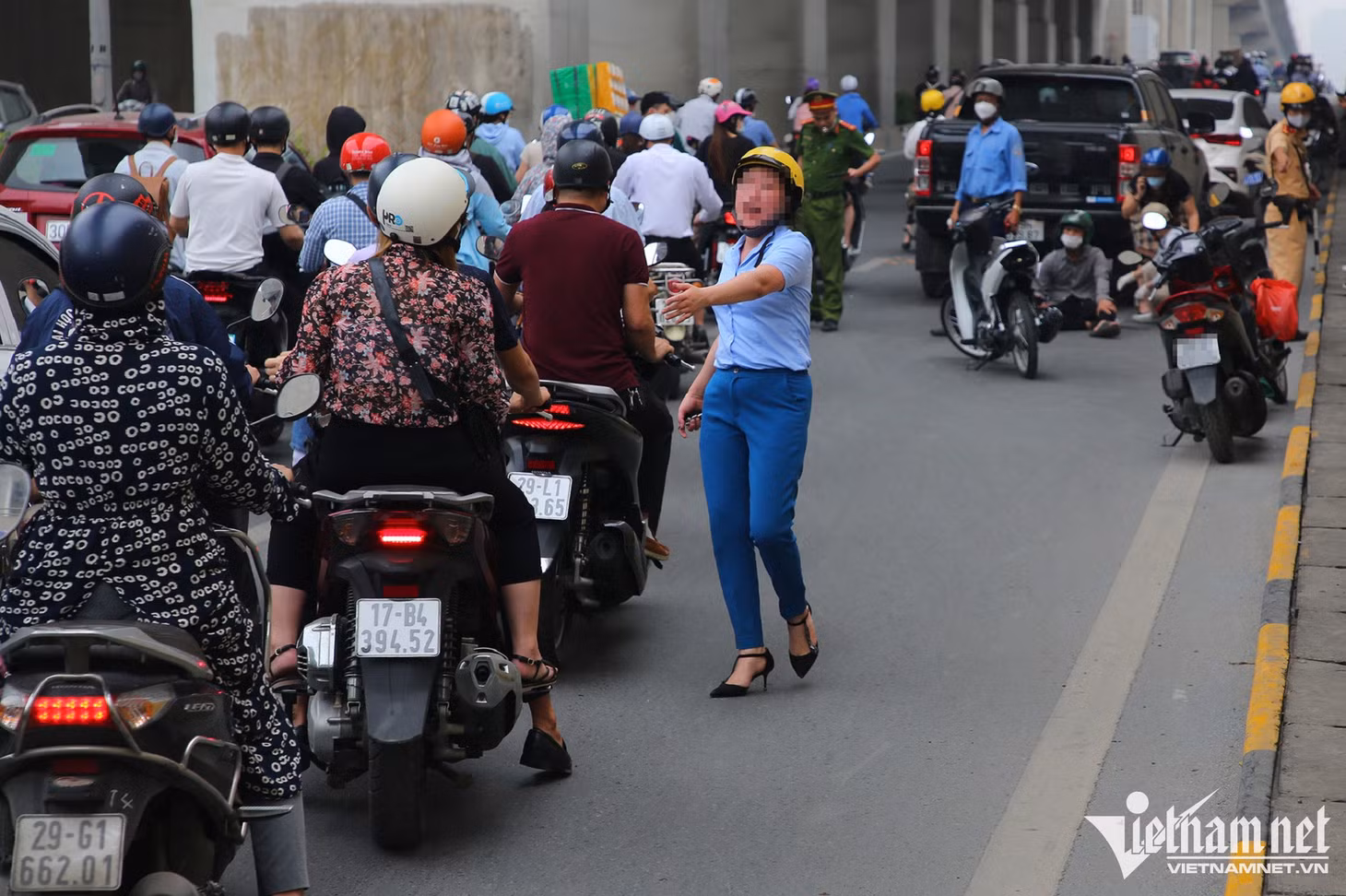 Một người phụ nữ giúp người bị tai nạn giao thông tại hầm chui Nguyễn Trãi
