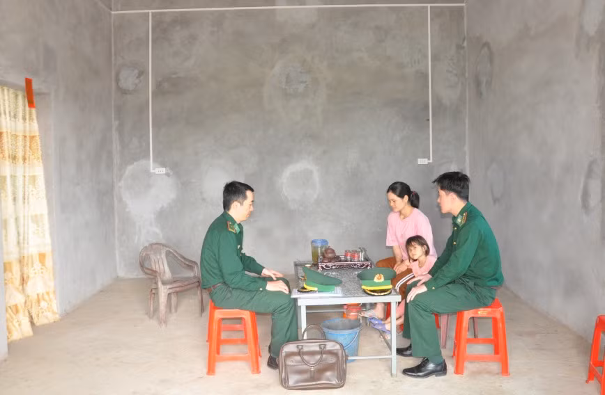 Cán bộ Đồn Biên phòng Quảng Đức trò chuyện với chị Phoòng Tài Múi (bản Nà Lý, xã Quảng Đức, huyện Hải Hà) trong 