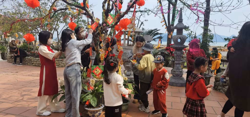 Du khách hái lộc câu đối tại chùa.