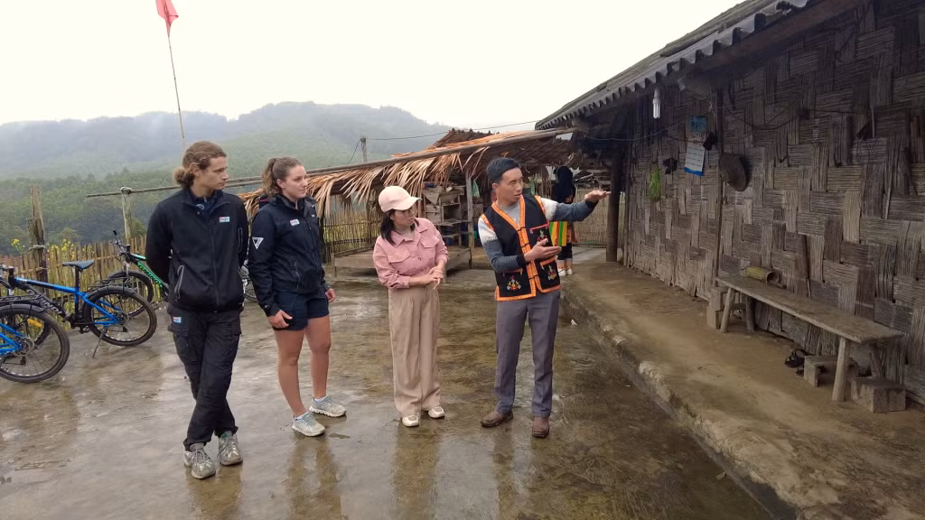 Hai thuyền phó nghe giới thiệu về nhà truyền thống của một nhà của người Dao tại thôn Khe Phương, xã Kỳ Thượng.