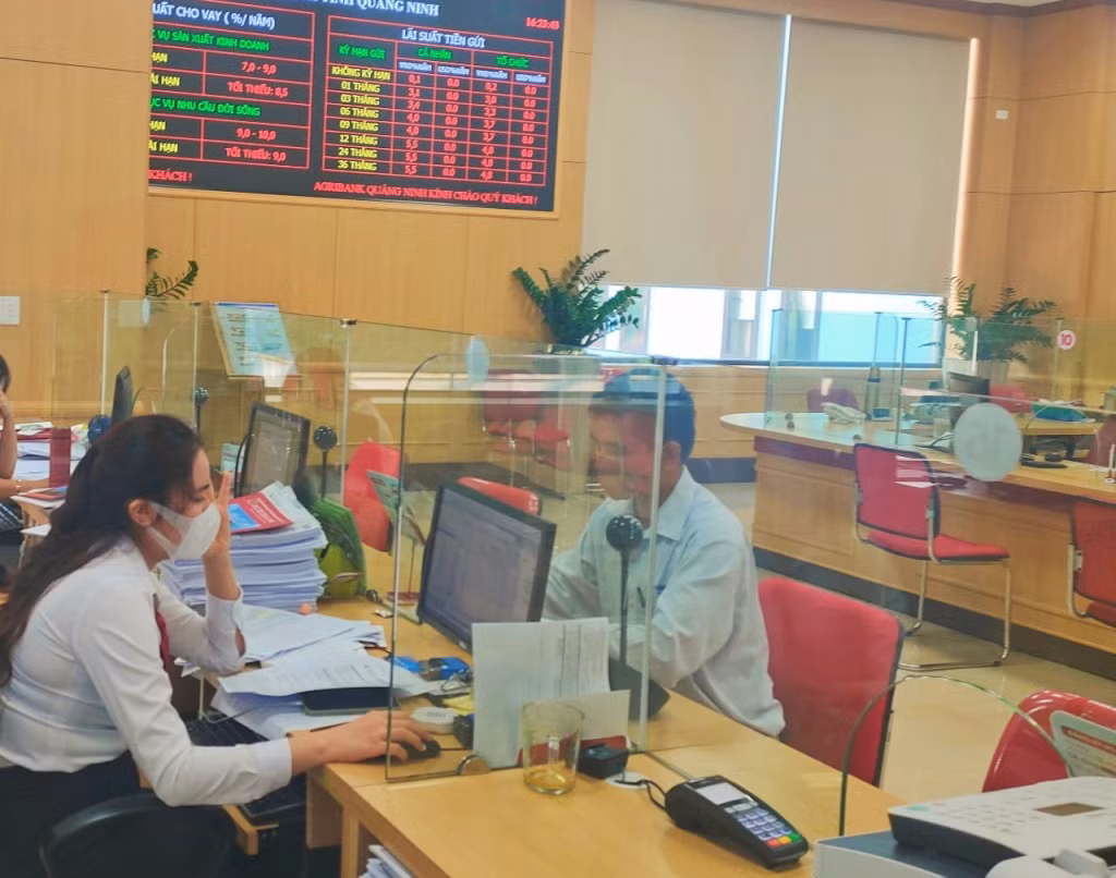 Cán bộ Ngân hàng NN&amp;PTNT chi nhánh Quảng Ninh trao đổi, hỗ trợ khách hàng thông tin về vay vốn.