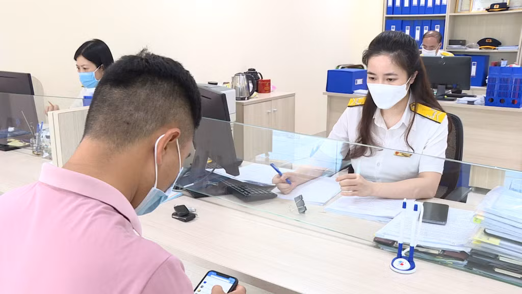  Cán bộ Chi cục Thuế khu vực Cẩm Phả - Vân Đồn - Cô Tô hướng dẫn người dân nộp thuế điện tử. 