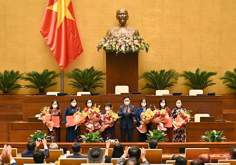 Chủ tịch Quốc hội Vương Đình Huệ trao Nghị quyết và tặng hoa Nhóm nữ đại biểu Quốc hội. (Ảnh: DUY LINH)