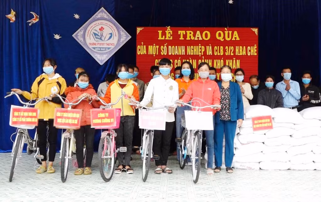 Bà Ngô Thị Thuận (ngoài cùng bên phải) kết nối các nhà hảo tâm trao tặng xe đạp, gạo cho học sinh hoàn cảnh khó khăn xã Đồn Đạc (huyện Ba Chẽ), tháng 11/2021.