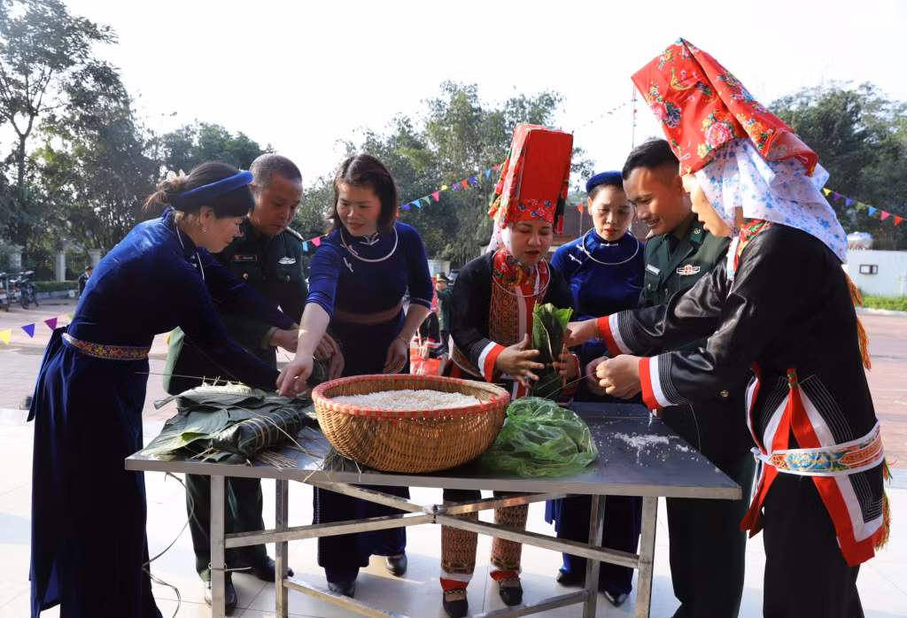Cán bộ, chiến sĩ Đồn BPCK Hoành Mô cùng nhân dân xã Đồng Văn gói bánh chưng.