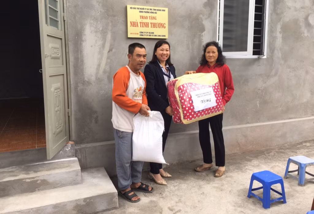 Chị Trần Thị Nhã, Chủ tịch Hội LHPN phường Hồng Hải (giữa), tặng quà cho hội viên có hoàn cảnh khó khăn.
