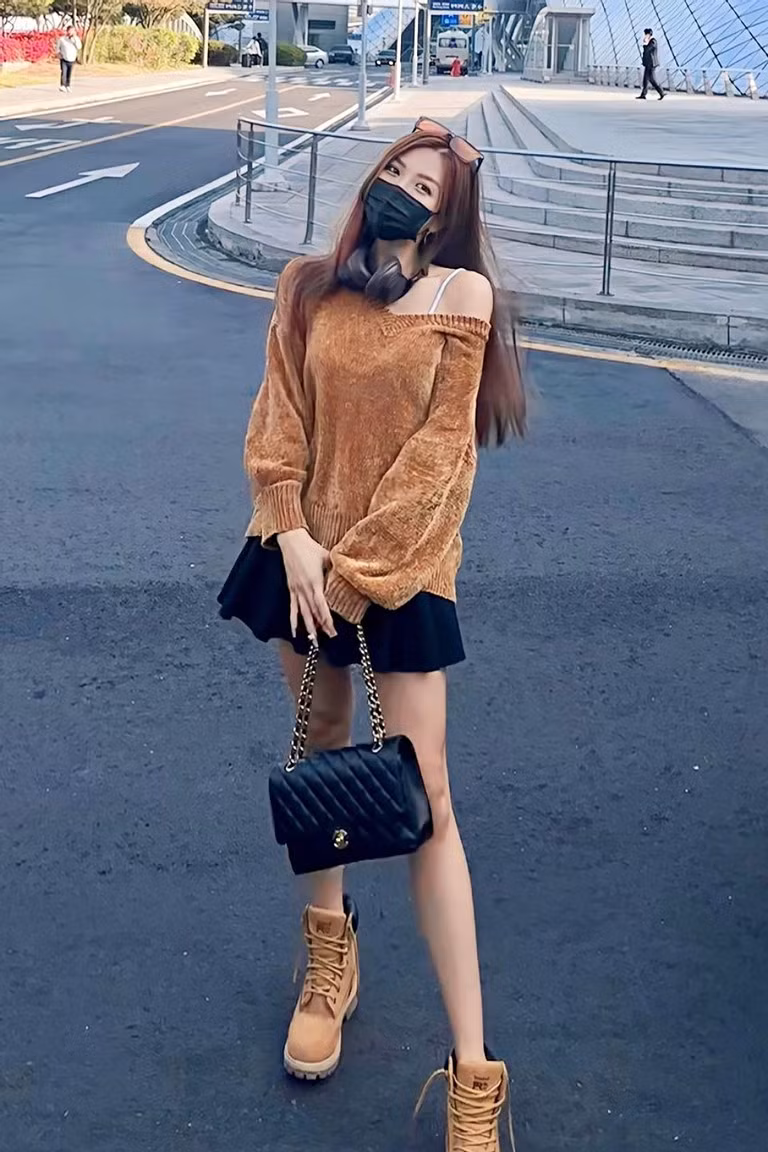 ‘Thời trang phang thời tiết’ của giọng ca 'Chocolate' trước cái lạnh tại Hàn Quốc. Cô mặc ’trên đông dưới hè’ khi phối áo len trễ vai và váy ngắn, giày boots phong cách leo núi.