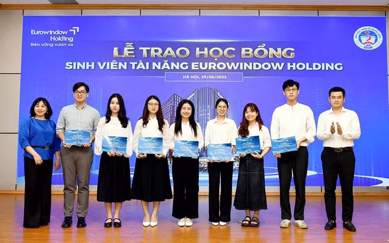 Đại diện Trường đại học Kinh tế quốc dân trao học bổng sinh viên xuất sắc. (Ảnh PHƯƠNG LINH)
