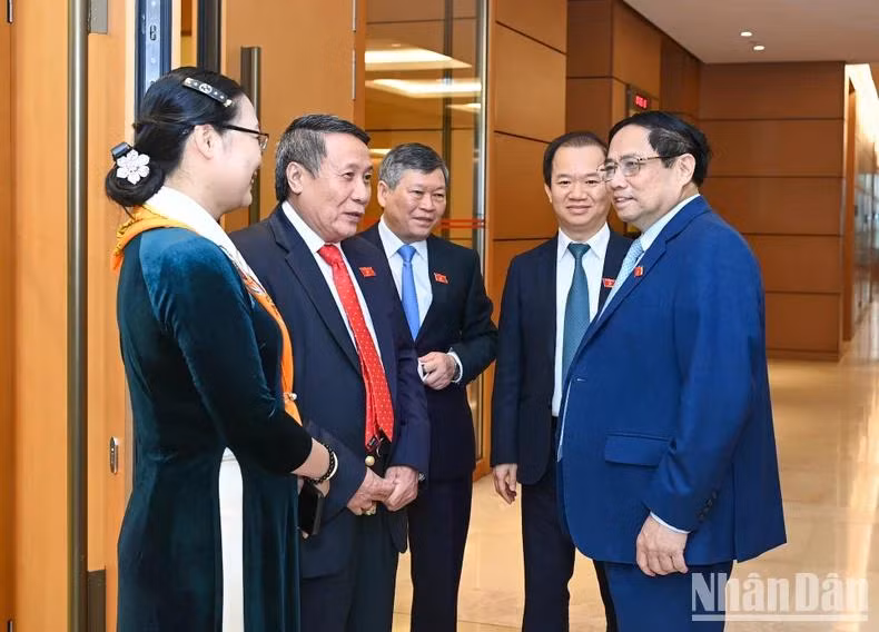 Thủ tướng Chính phủ Phạm Minh Chính trao đổi với các đại biểu Quốc hội bên lề kỳ họp. (Ảnh: DUY LINH)