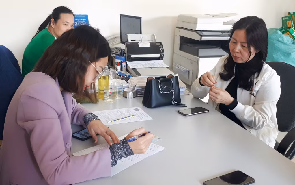 Cán bộ BHXH TP Cẩm Phả hướng dẫn làm thủ tục đăng ký cho người dân tham gia BHXH tự nguyện.