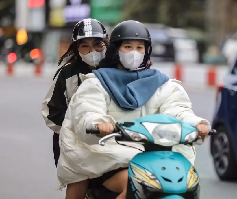 Người dân Hà Nội thêm áo rét khi di chuyển trên đường. (Ảnh: Thanh Tùng/TTXVN)