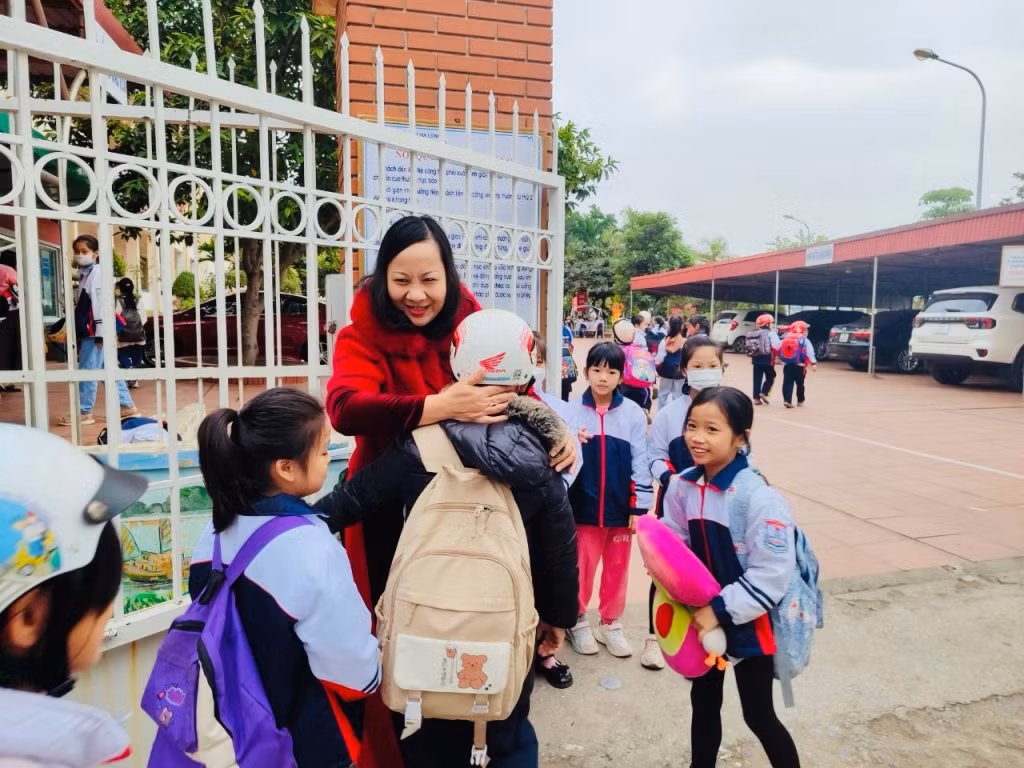 Cô giáo Nguyễn Bích Thủy đón học sinh mỗi buổi sáng tại cổng trường học.