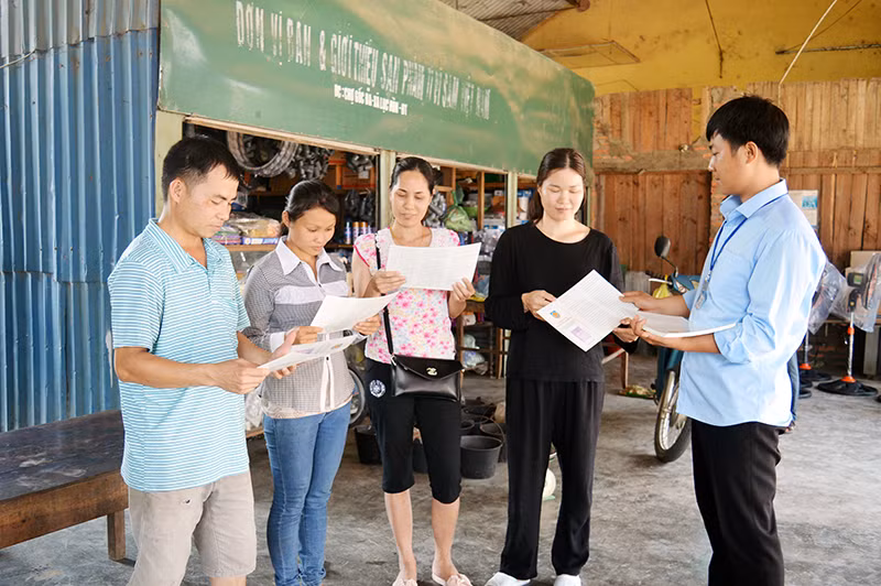Cán bộ Tư pháp - Hộ tịch xã Lục Hồn (huyện Bình Liêu) tuyên truyền pháp luật cho các tiểu thương và người dân tại chợ Lục Hồn. Ảnh: Trúc Linh