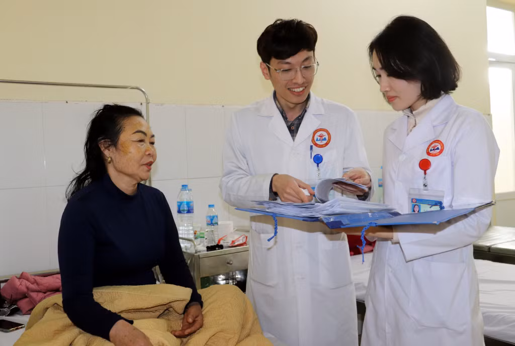 Bác sĩ Phạm Thanh Tùng khám bệnh cho bệnh nhân cao tuổi, đồng thời hướng dẫn chuyên môn cho các đồng nghiệp trẻ trong khoa.