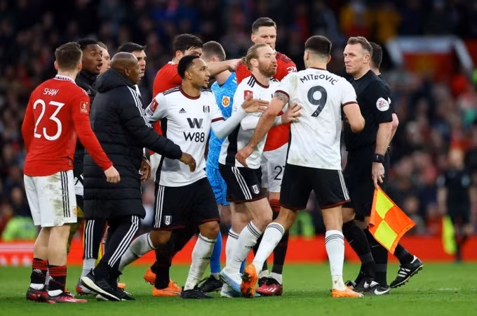 Cầu thủ hai đội can ngăn Aleksandar Mitrovic khi tiền đạo Fulham muốn gây sự với trọng tài. Ảnh: Reuters