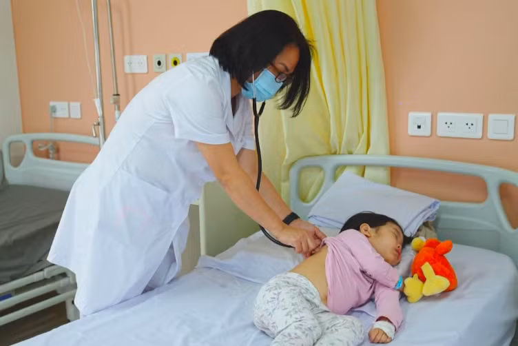 Bác sĩ Phạm Thị Thuận thăm khám cho bệnh nhi tại viện. Ảnh: BSCC