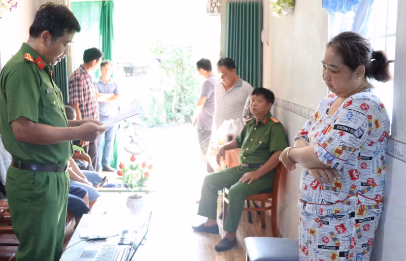 Cán bộ điều tra tống đạt lệnh bắt tạm giam bị can Hồ Thị Kim Xuyến.