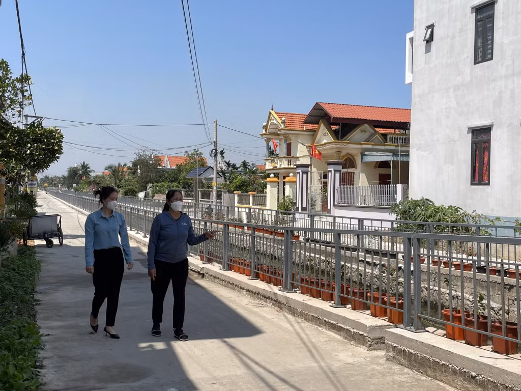 Phó Bí thư Đảng ủy xã Sông Khoai Vũ Thị Hoa (bên trái) trao đổi với người dân thôn 8 về tuyến đường NTM do 81 hộ dân đồng thuận hiến đất làm đường.