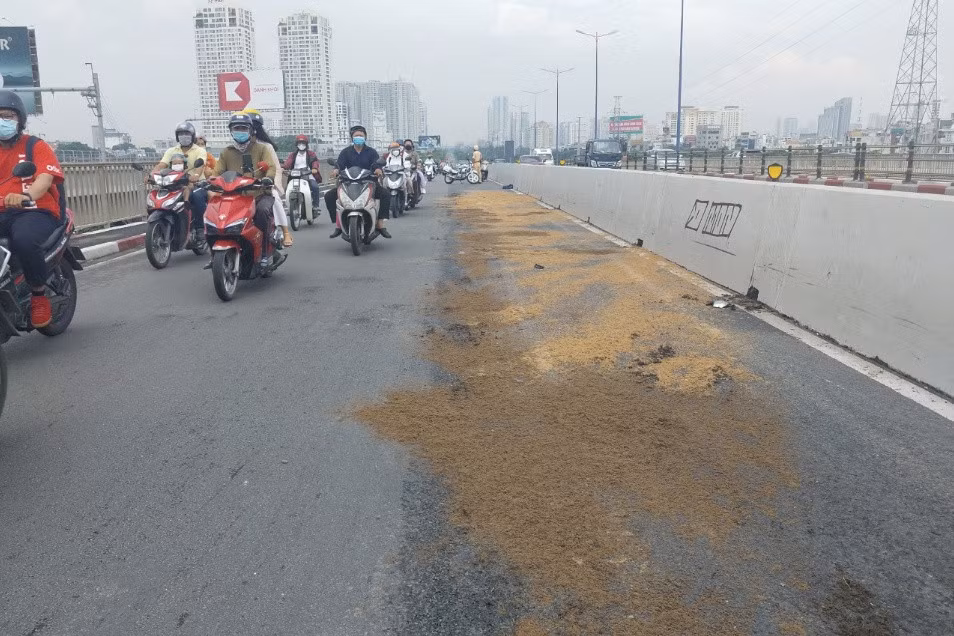 Lực lượng chức năng dùng cát rải trên nền đường để khắc phục sự cố. Ảnh: N.A.