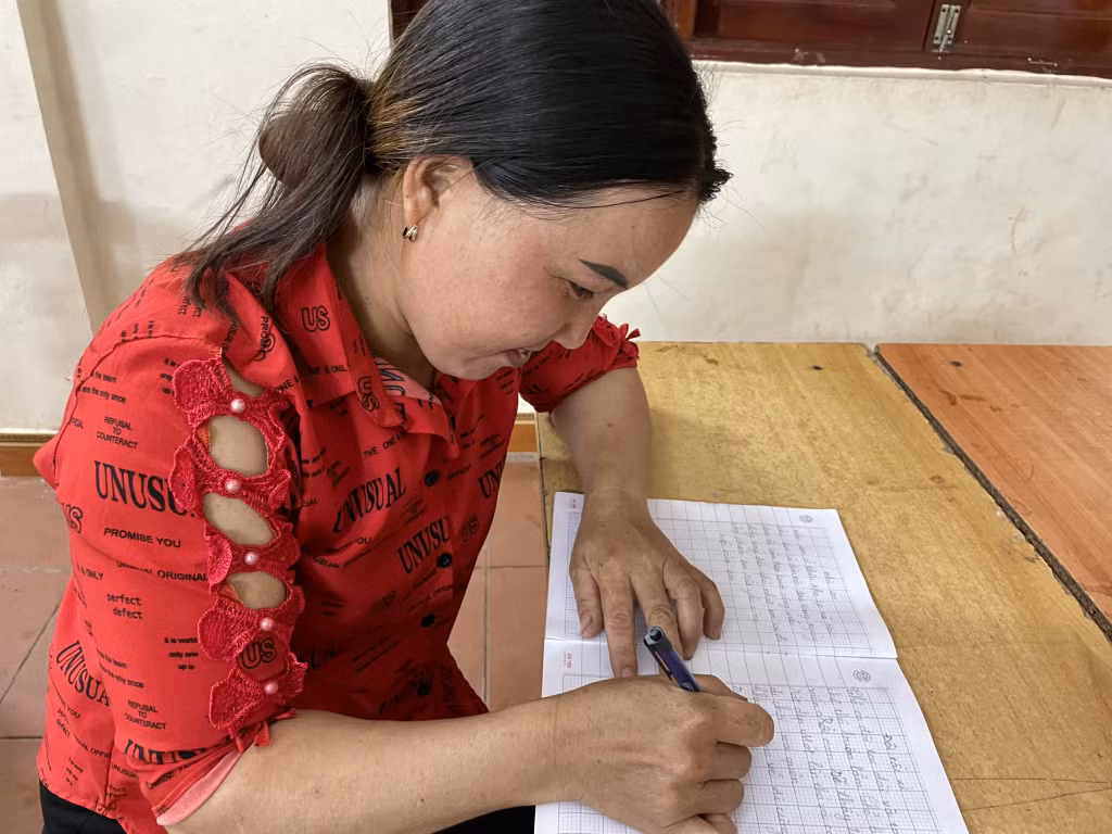 Chị Voòng Thị Hồng, thôn Khe Lẹ, xã Hà Lâu, chăm chỉ viết những đoạn văn ngắn trên vở ô ly.