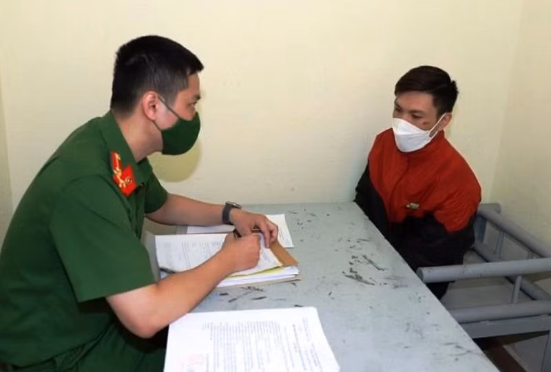 Đối tượng Trần Văn Tuấn (áo đỏ) tại trụ sở Công an quận Hồng Bàng, TP Hải Phòng.