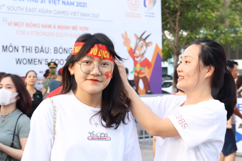 CĐV dán lá cờ đỏ trên má để cỗ vũ cho tuyển Việt Nam.