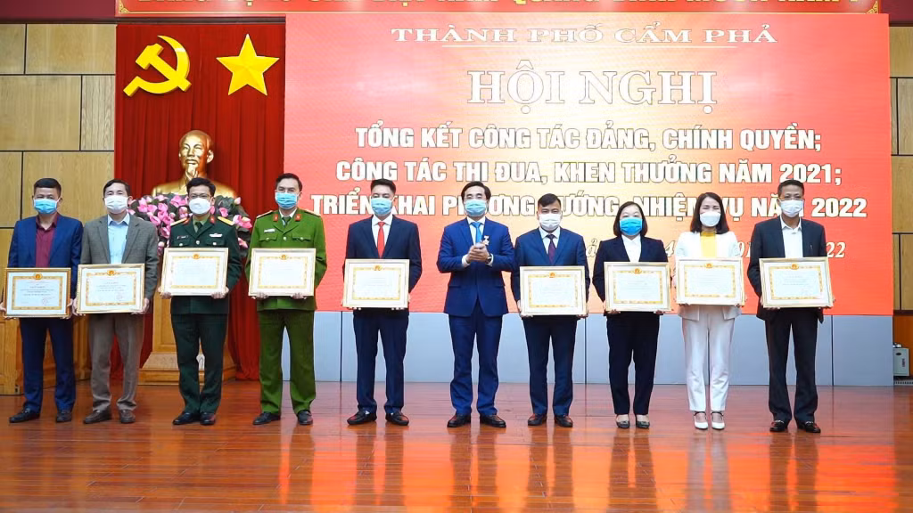 Lãnh đạo phường Cửa Ông (thứ 4 phải sang) nhận giấy khen “Hoàn thành xuất sắc nhiệm vụ” năm 2021 của Thành ủy Cẩm Phả.