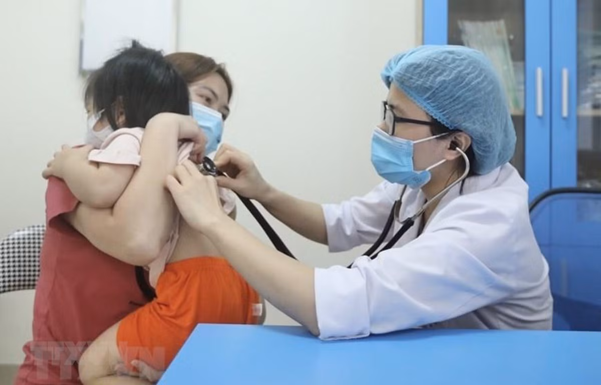 Bác sỹ Bệnh viện Bệnh nhiệt đới Trung ương khám cho bệnh nhi xuất hiện triệu chứng cúm A. (Ảnh: Minh Quyết/TTXVN)