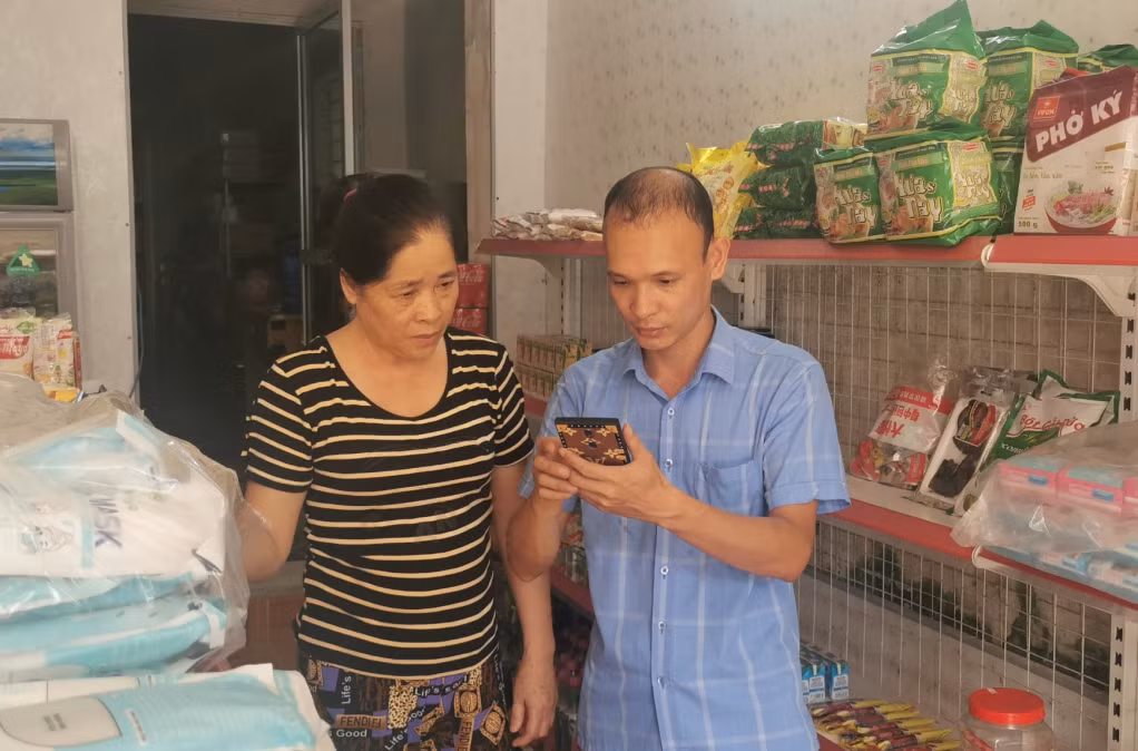 Thành viên Tổ công nghệ số cộng đồng khu phố Lê Hồng Phong, thị trấn Đầm Hà hướng dẫn người dân khai thác, sử dụng Internet, thanh toán điện tử.