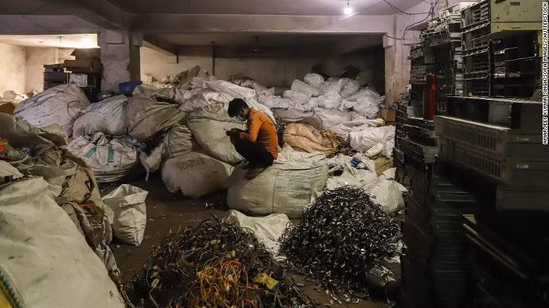 Người đàn ông ngồi trên đống rác thải điện tử tại một cửa hàng ở New Delhi, Ấn Độ tháng 7/2020. (Ảnh: Shutterstock)