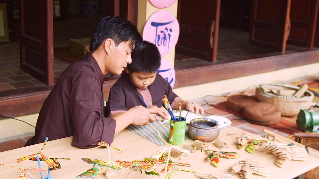 Anh Phong hướng dẫn du khách "nhí" tô màu lên chuồn chuồn tre.