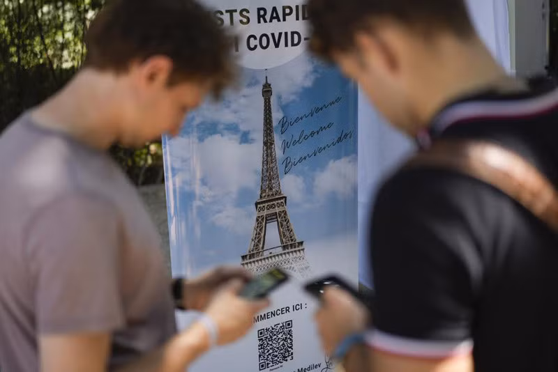 Du khách quét mã QR khai báo thông tin về Covid-19 tại điểm thăm quan nổi tiếng Tháp Eiffel ở Paris hôm 21/7 (Ảnh: AP)