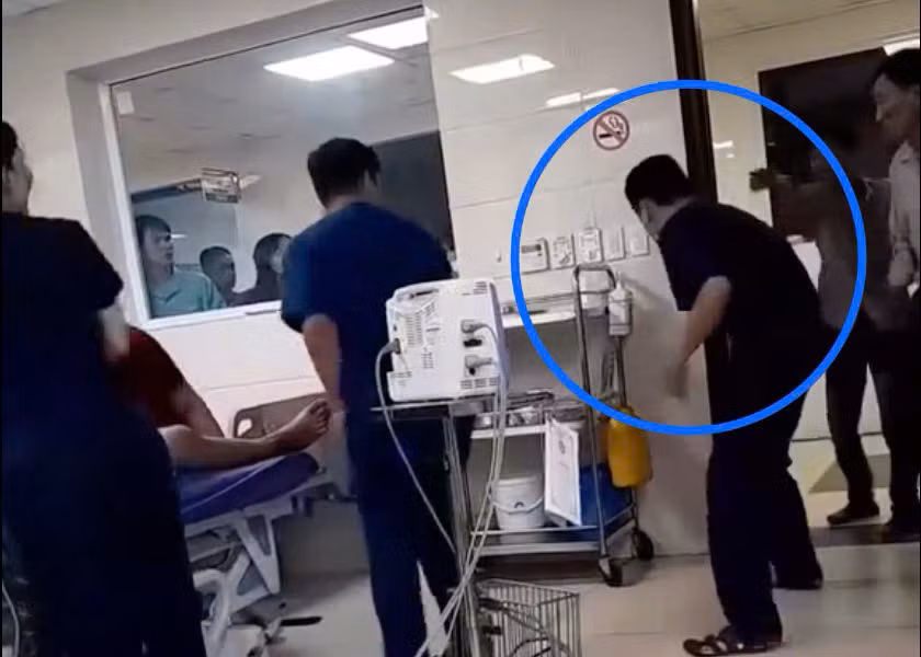 Nam điều dưỡng bị người nhà bệnh nhân đạp vào bụng khi đang đi lấy dụng cụ cấp cứu. Ảnh cắt từ clip