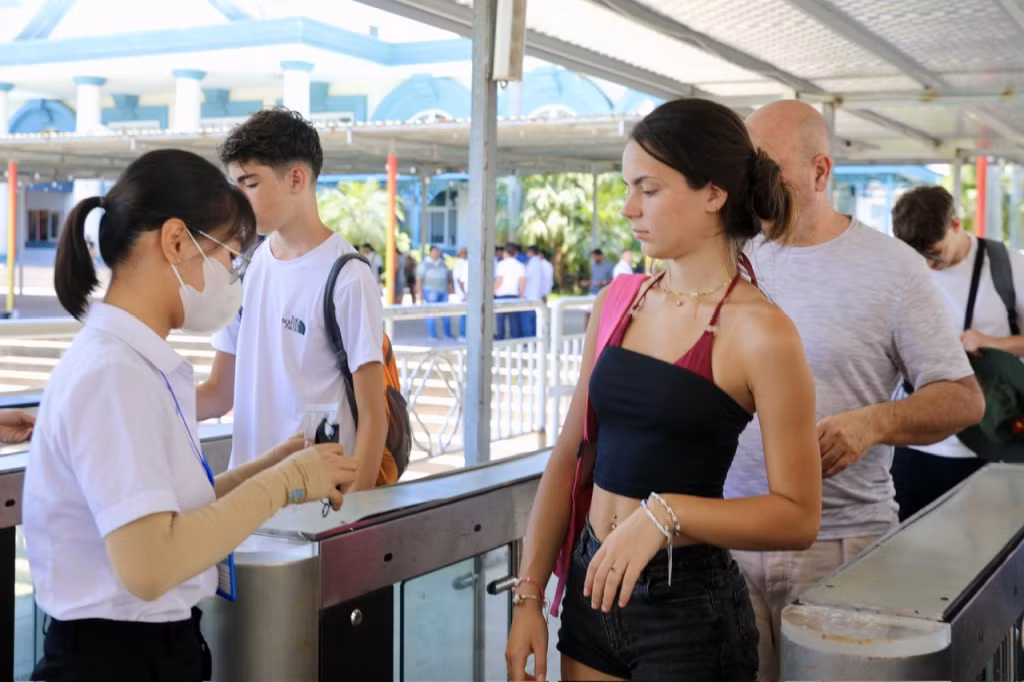 Du khách nước ngoài làm thủ tục xuống tàu tham quan vịnh.