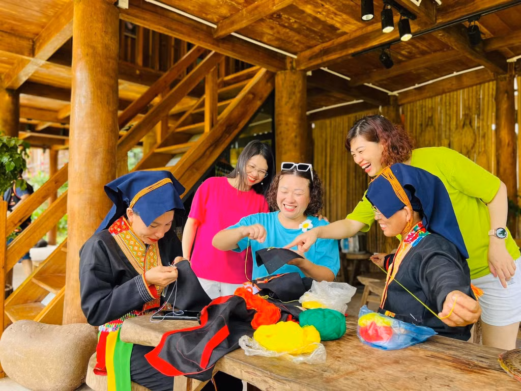 Du khách trải nghiệm thêu trang phục đồng bào DTTS tại Kỳ Thượng AmVap Farm (TP Hạ Long). (Ảnh đơn vị cung cấp)