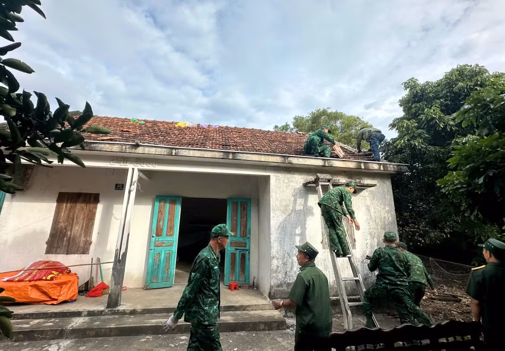  Cán bộ Đồn BP Trà Cổ giúp bà Dương Thị Đo sửa chữa nhà ở.