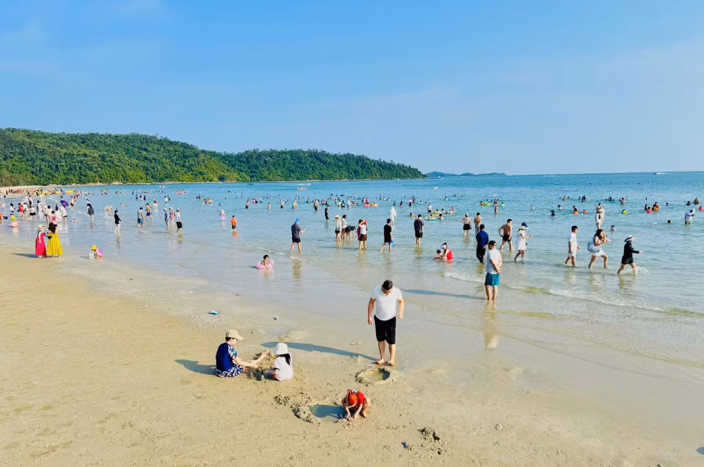 Du khách tận hưởng làn nước trong xanh tại bãi biển Cô Tô.