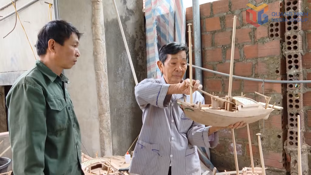 Ông Lê Đức Chắn hướng dẫn thợ cách làm mô hình thuyền ba vách.