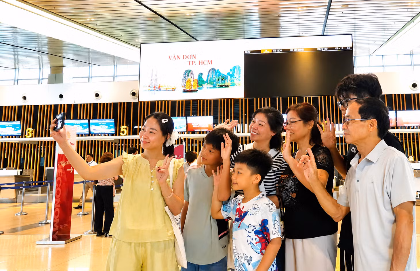 Nhiều hành khách chụp ảnh cùng gia đình trước chuyến bay đi TP Hồ Chí Minh. 
