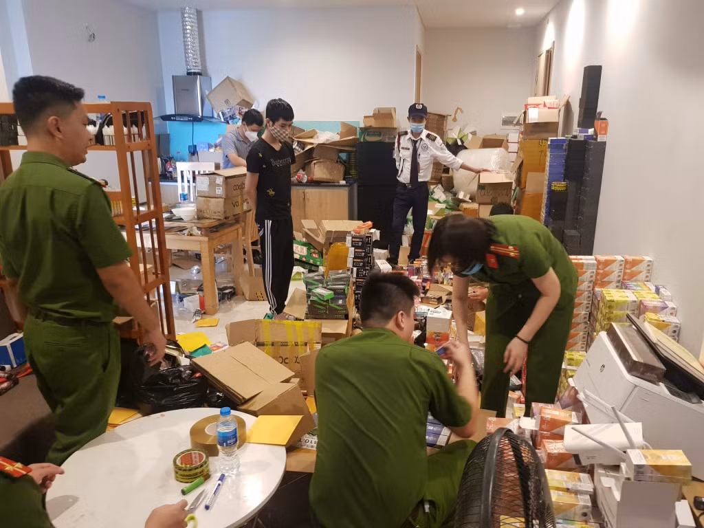 Công an TP Hạ Long thu giữ tại nhà Phan Trường Sơn (đối tượng mặc áo đen) ở Tòa A, chung cư GreenBay Garden, thuộc tổ 32, khu 2, phường Hùng Thắng, TP Hạ Long nhiều loại thuốc lá không rõ nguồn gốc vào ngày 25/8/ 2021. Ảnh Nguyễn Khánh (CTV)